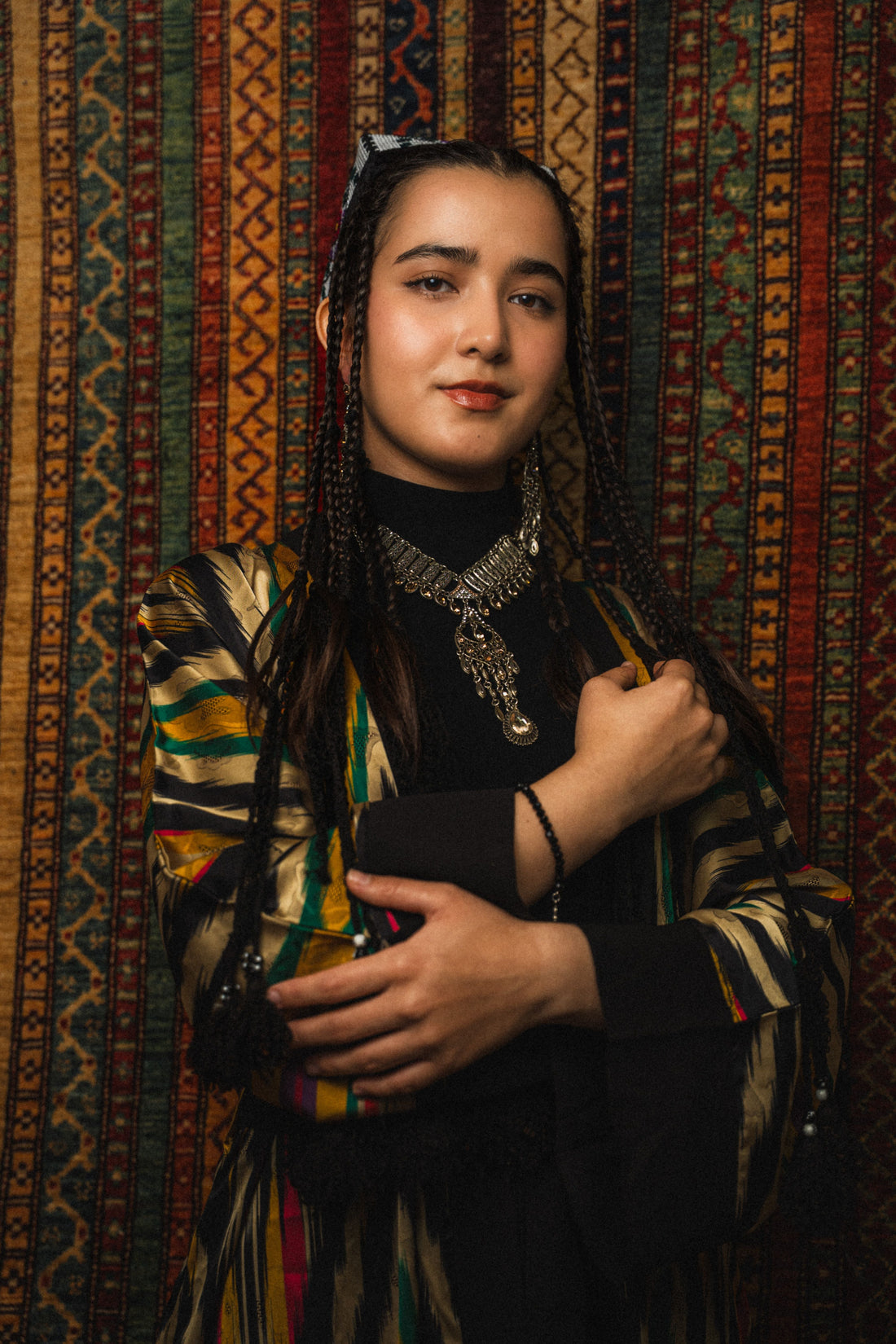 Portrait d'une jeune femme d'Asie centrale portant des tresses traditionnelles et une tenue traditionnelle.