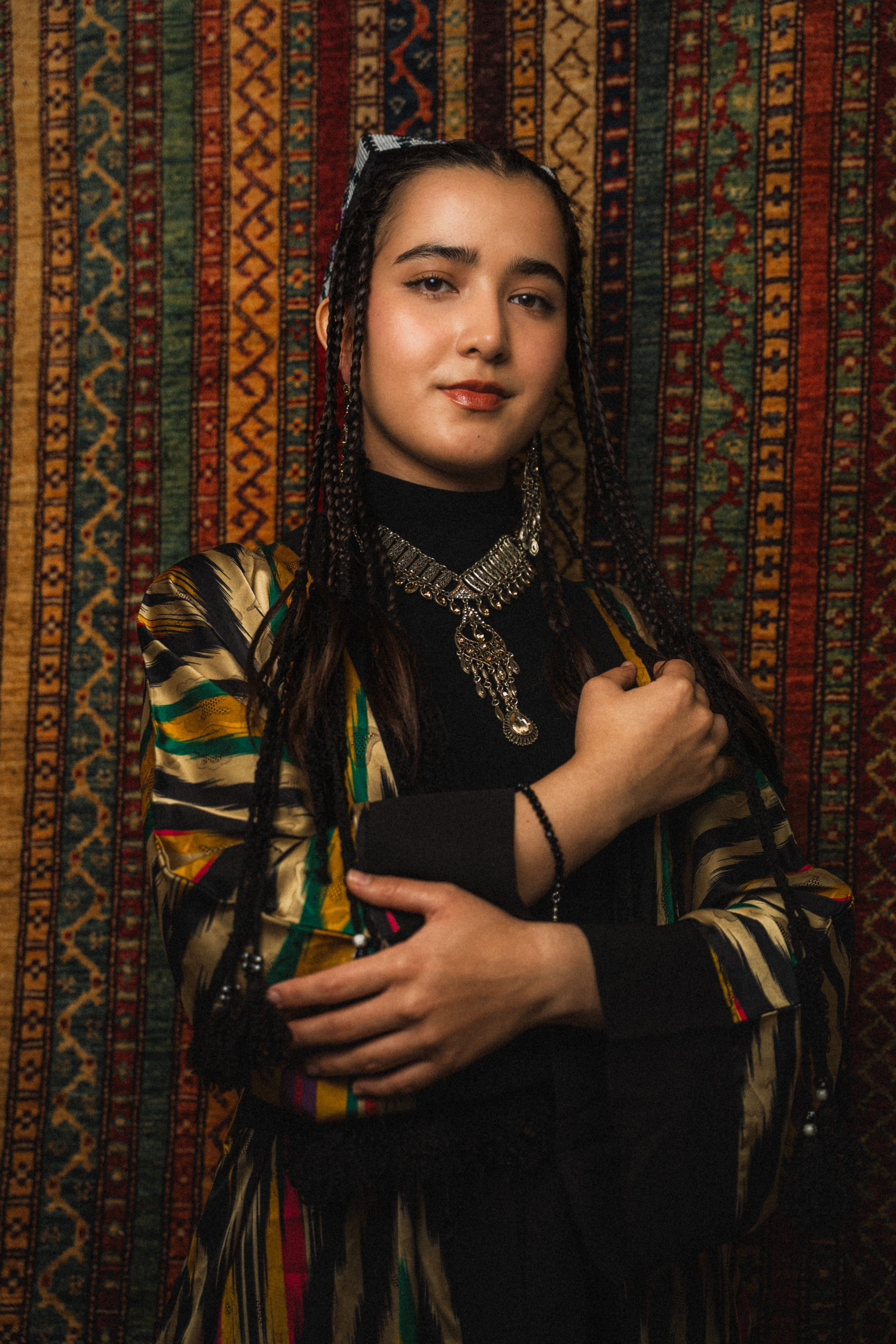 Portrait d'une jeune femme d'Asie centrale portant des tresses traditionnelles et une tenue traditionnelle.